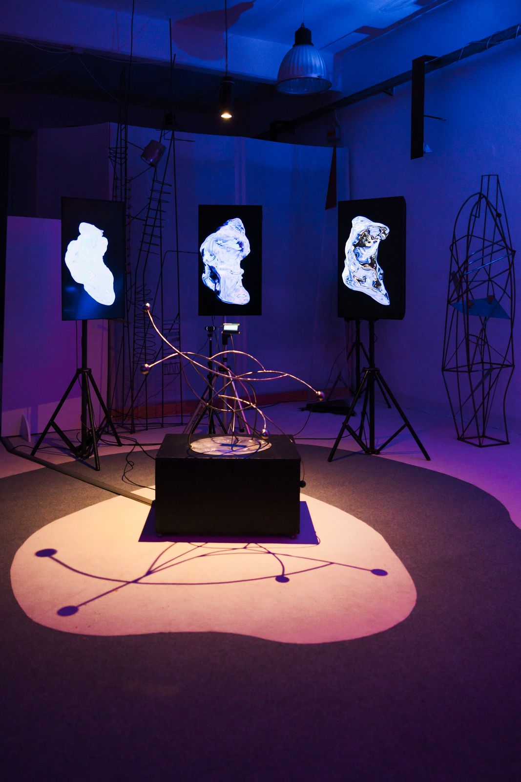L'installazione Ánimas illuminata di blu, con la scultura su un piedistallo nero